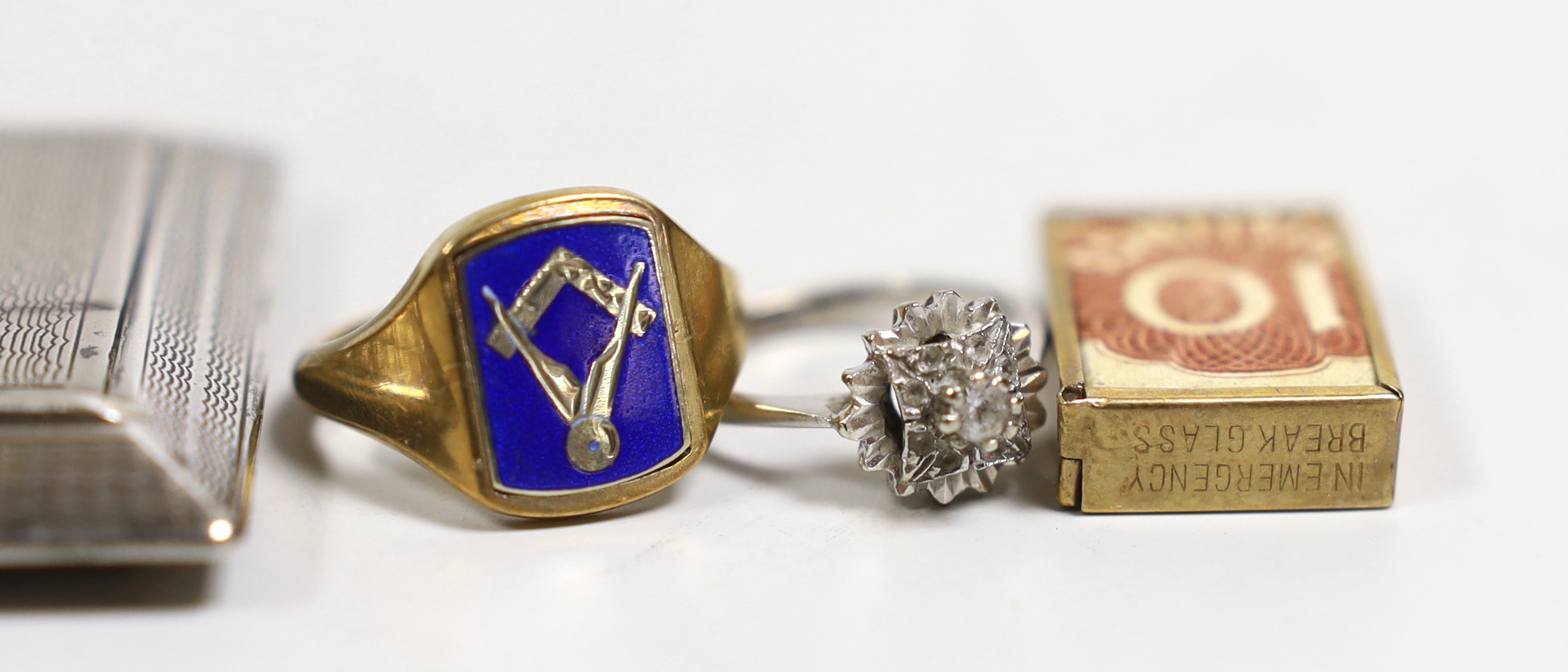 An early 1960's 9ct gold and enamel masonic ring, size P, a 9ct gold mounted oval cameo shell brooch, one other cameo brooch, a 9ct gold mounted charm, an 18ct white metal and diamond chip ring and a silver compact (lack